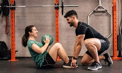 Coach accompagnant un membre sur le plateau de musculation