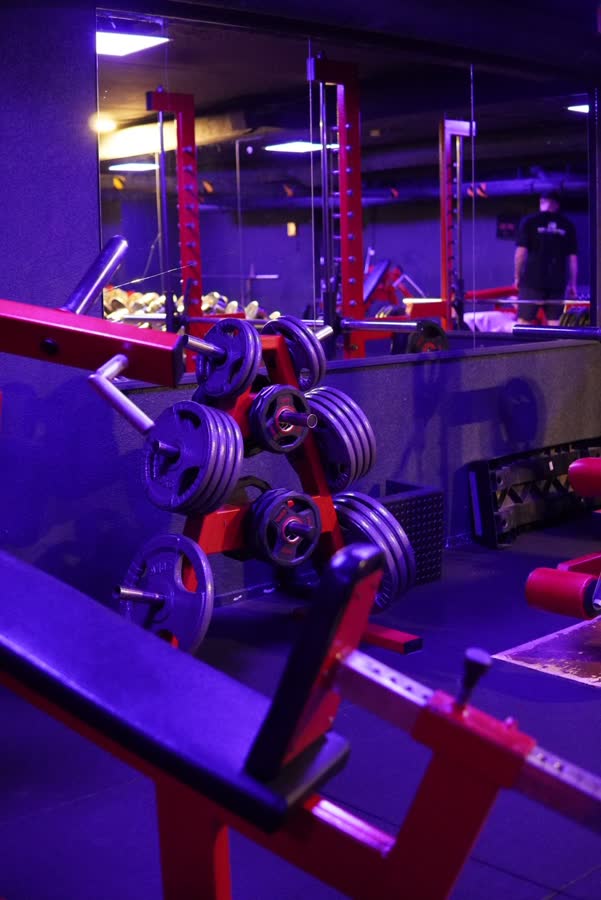 Rack à disques rouge devant un mur de miroirs, ambiance bleue