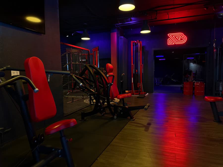 Machines rouges pour le haut du corps devant le néon B rouge, parquet éclairé de rouge et de bleu